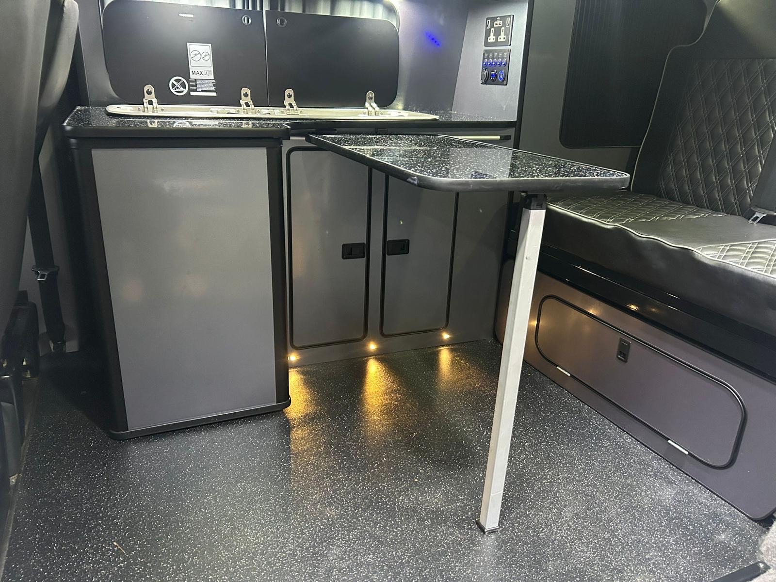 Luxury interior of a Volkswagen T6 4 berth camper van available for hire from NW Car Hire, featuring quilted leather seating.